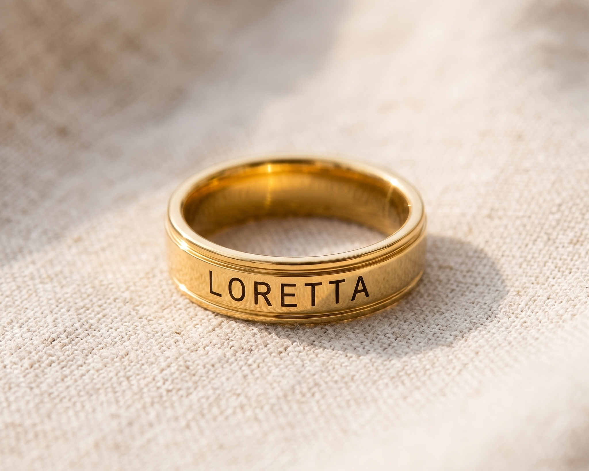 Two plain wedding bands resting on pale linen, one turned to show its inner surface