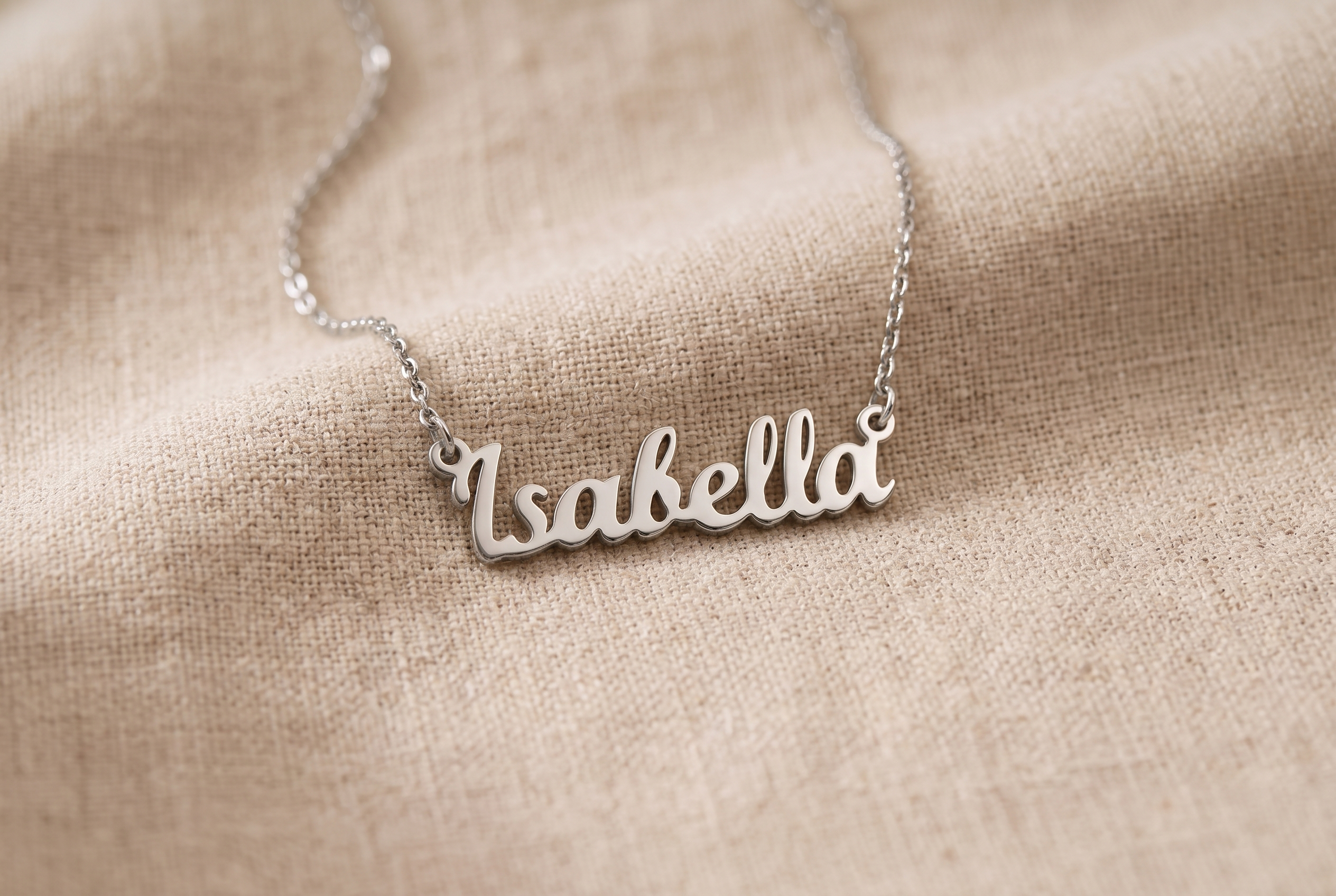 Personalised name necklace resting on an old family photograph beside a vintage locket
