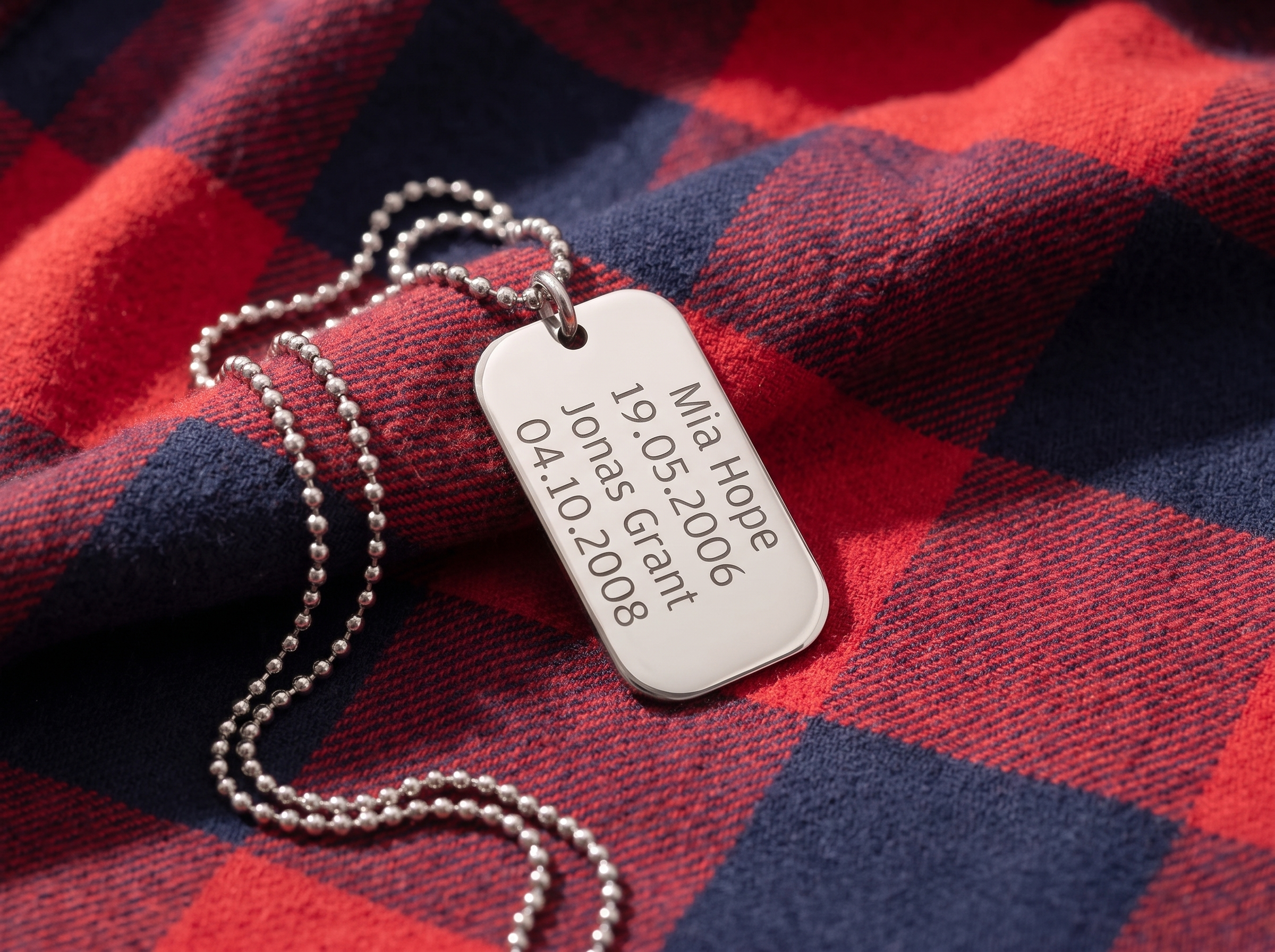 Silver dog tag engraved with a child's handwritten Love you Daddy
