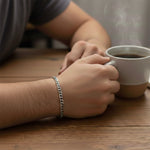Silver curb chain bracelet on wrist close-up, waterproof non-tarnish unisex jewelry crafted for strength and daily wear.