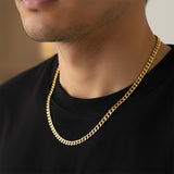 Gold curb chain necklace worn by man, waterproof non-tarnish unisex chain with bold timeless appeal.