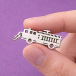 Belle Fever silver fire truck charm personalised firefighter gift, detailed emergency truck pendant shown in hand for size reference