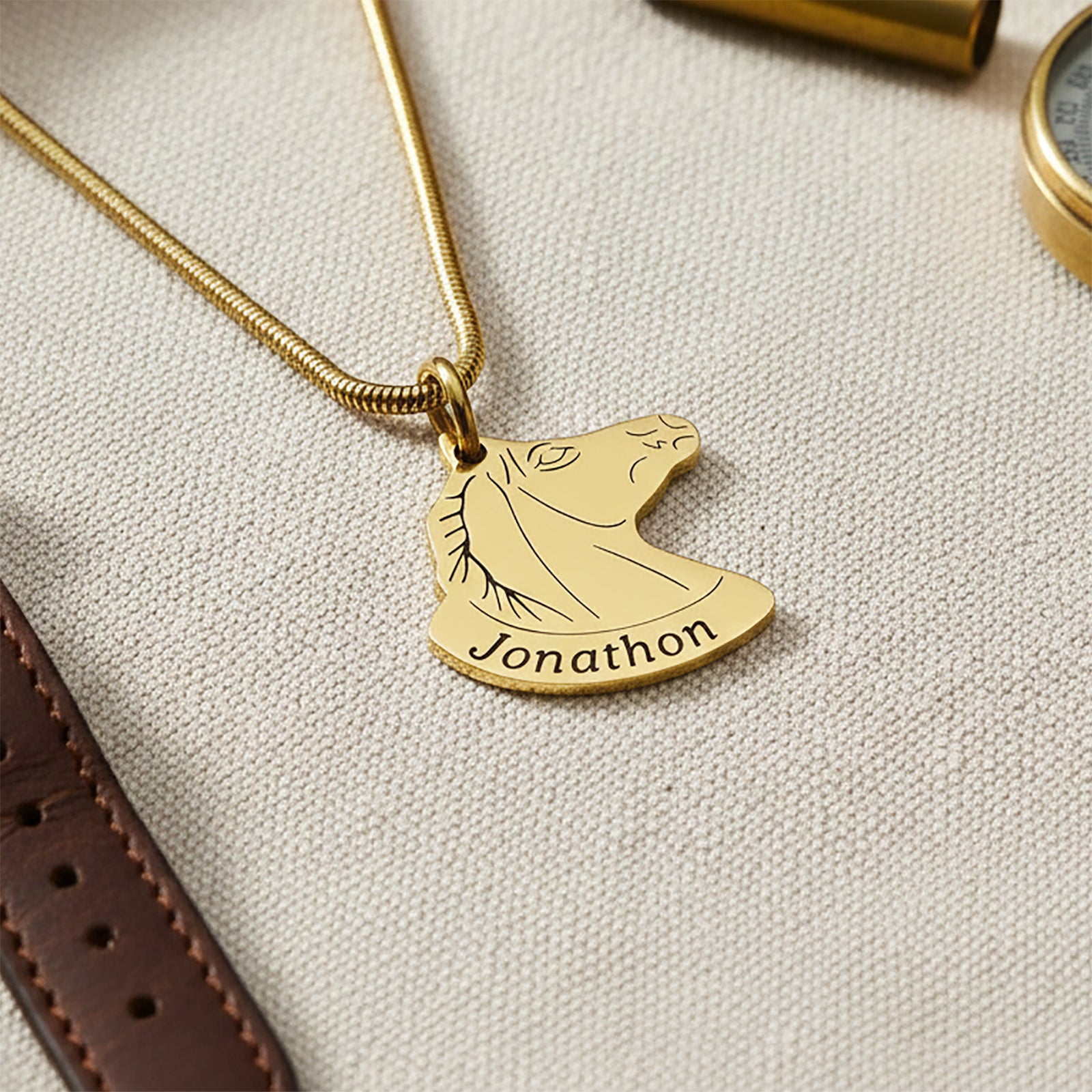 Horse Head Necklace with Custom Name Belle Fever gold pendant on neutral beige fabric, personalised horse jewellery with custom engraving, elegant equestrian gift for riders.