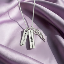 Silver Memory Cremation Necklace by Belle Fever — elegant urn pendant with angel wing and name tag, symbolising eternal love and remembrance.