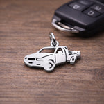 Belle Fever silver pick up charm on wooden table with car keys, meaningful truck driver gift idea.