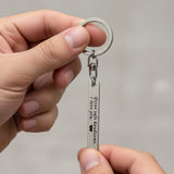 Belle Fever silver reminder tag keychain held in hand, custom engraved bar keepsake with personal message, everyday carry gift