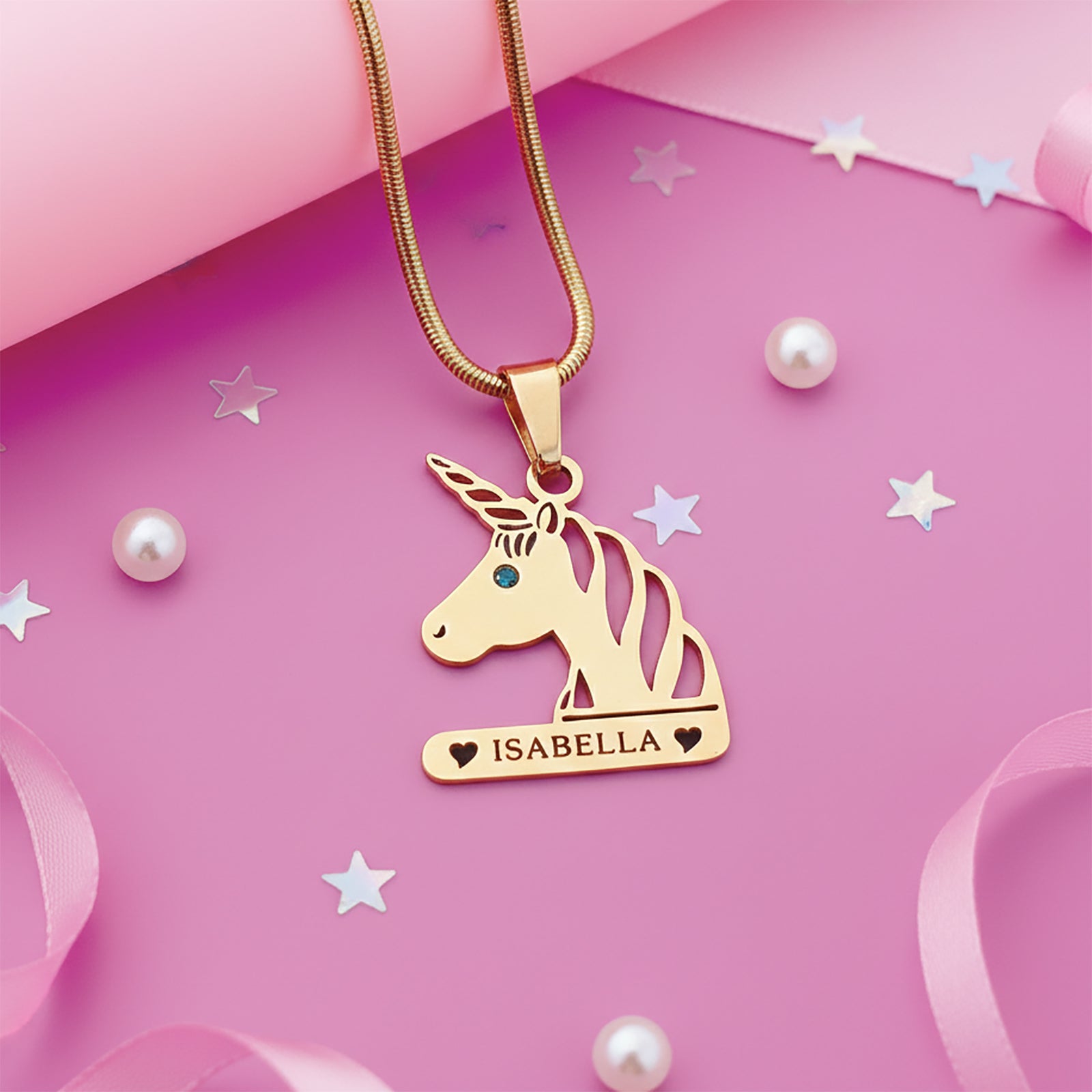 Unicorn head name necklace with birthstone accent styled on pink decorative setting.