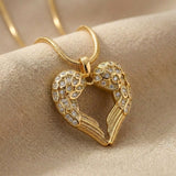 Angels Heart necklace with gold heart angel wings pendant on delicate chain displayed on neutral background