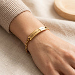 Woman wearing gold bar bracelet with custom engraving on plate design