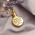 Circle Cremation Necklace by Belle Fever in gold, round memorial pendant with engraved quote, luxury ashes holder jewellery styled on neutral fabric, meaningful remembrance keepsake gift.