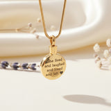 Belle Fever Circle Cremation Necklace gold edition, engraved ashes pendant styled on ivory fabric with soft floral accents, meaningful memorial jewellery gift for loss and remembrance.