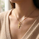 Woman wearing cross name necklace with engraved cross pendant on delicate chain