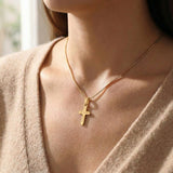 Woman wearing cross name necklace with engraved cross pendant on delicate chain