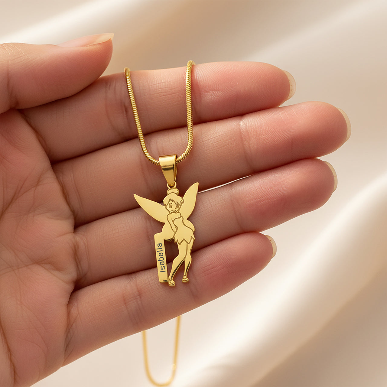 Fairy Name Necklace by Belle Fever — gold fairy pendant displayed in hand, a charming personalised keepsake necklace designed for children who love magic and fairytales.