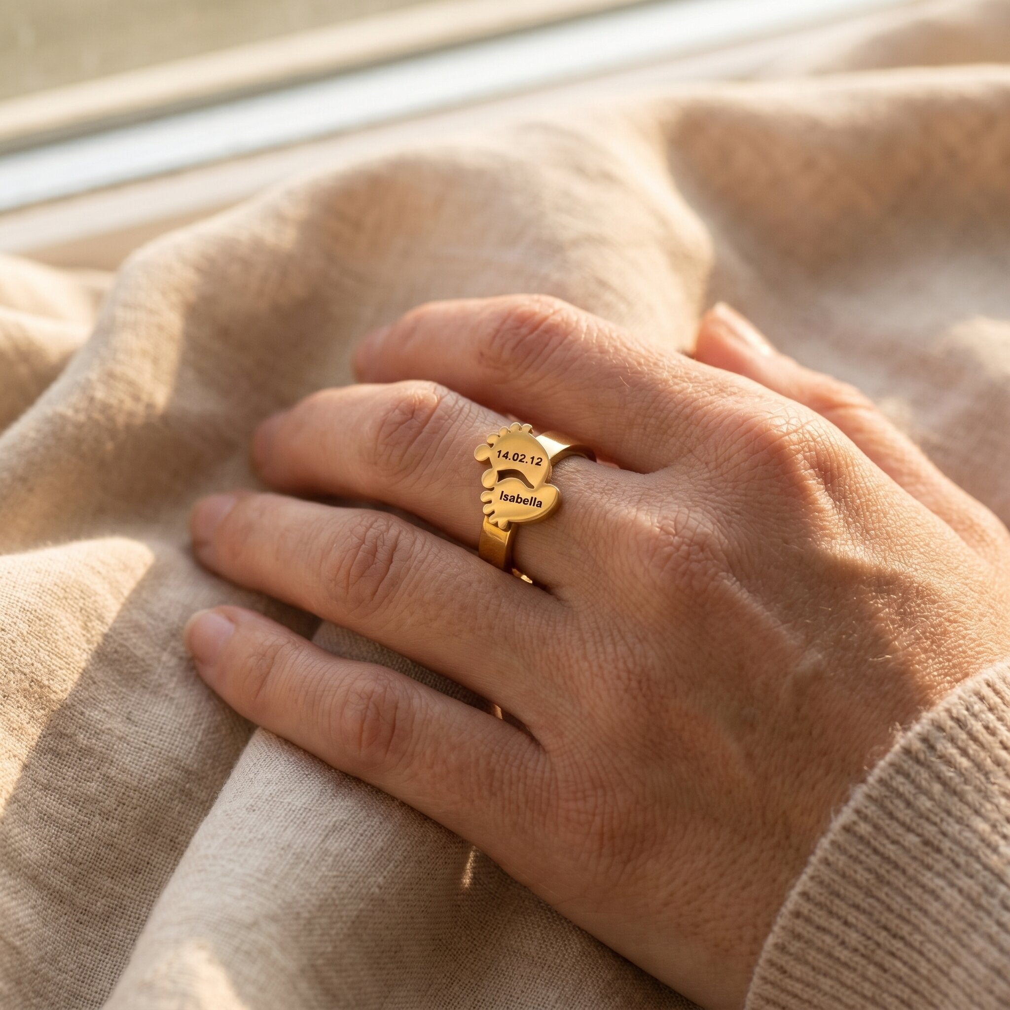 Woman wearing footprint ring with engraved detail, personalised jewellery for mum and baby keepsake