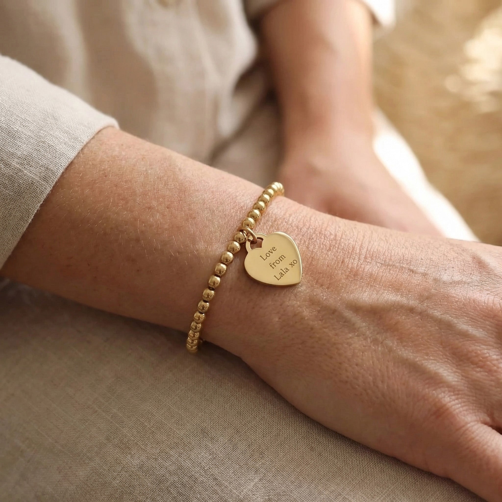 Woman wearing Forever In My Heart Charm Bracelet with engraved heart charm, personalised jewellery lifestyle image