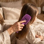 Detangling hair brush in use for gentle brushing, reducing tangles and improving hair care routine