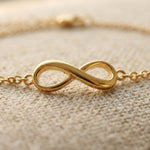 Close up of infinity bracelet with polished infinity symbol on fine chain