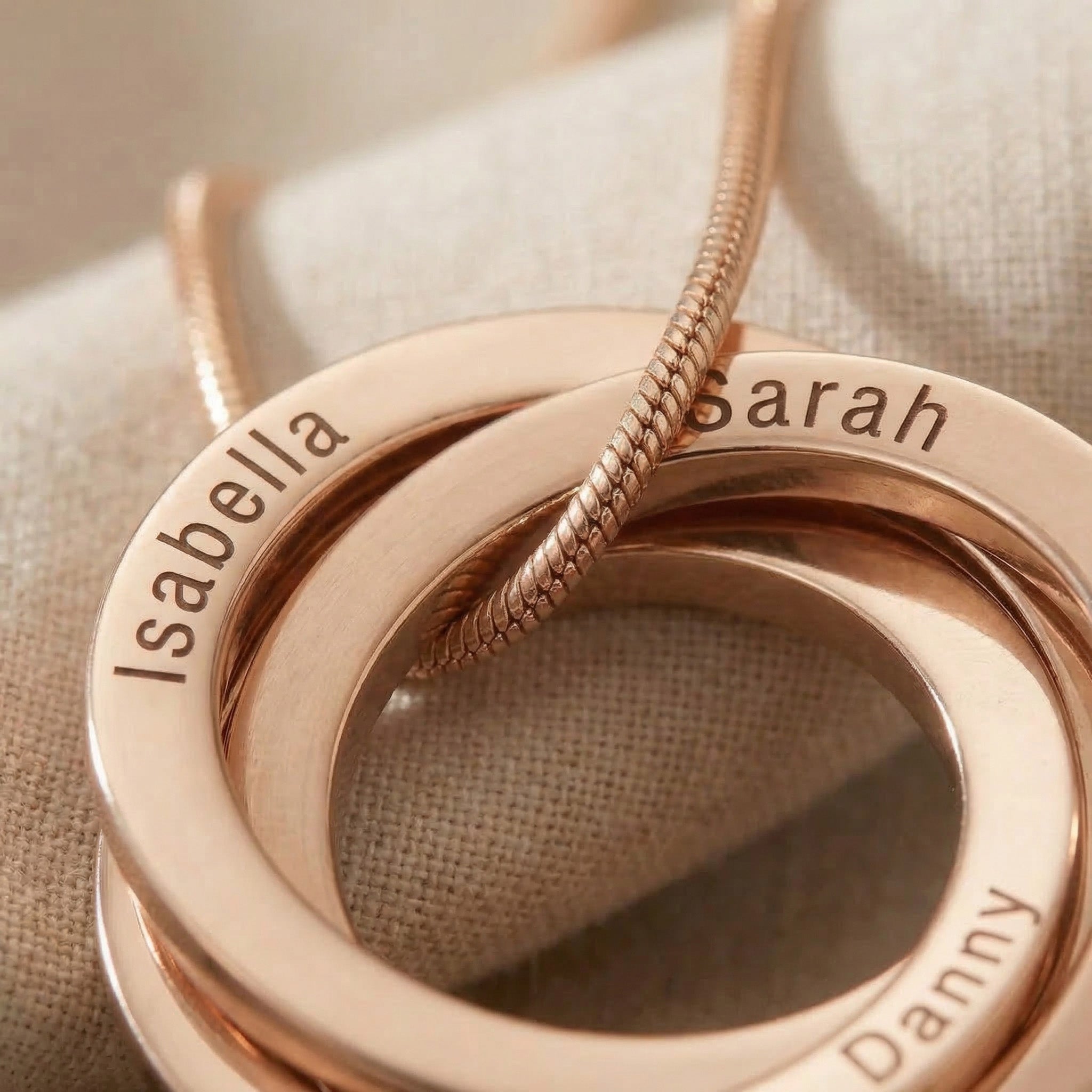 Close-up of Interlinked Love Ring Necklace showing engraved detail on interlocking rings