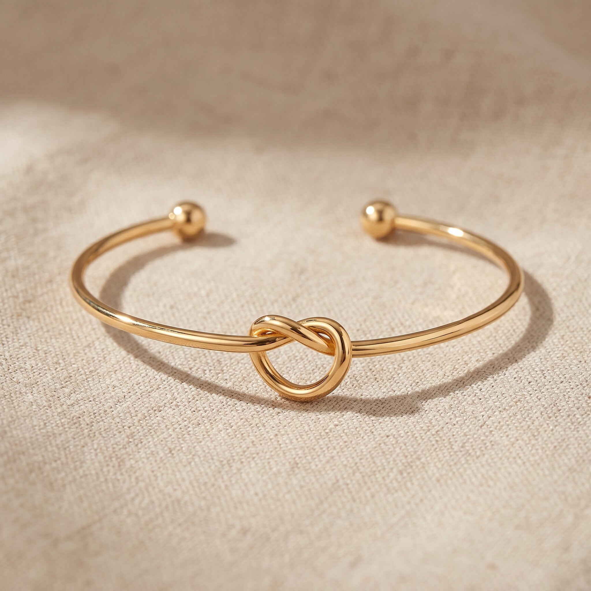 Knot bangle in gold with symbolic knot design, meaningful open cuff bracelet jewellery gift for her