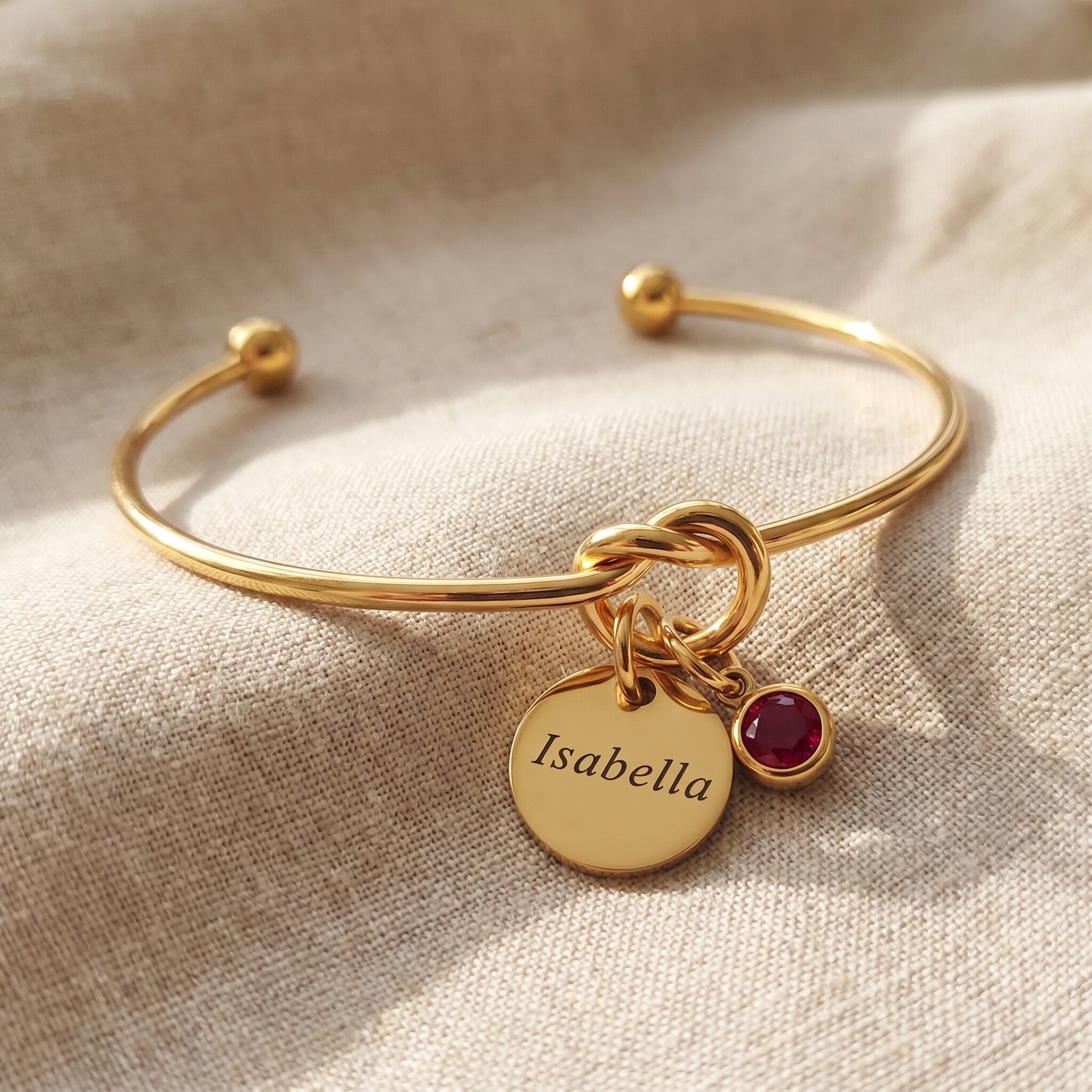Knot bangle with personalised charm option, symbolic bracelet with engraved disc and birthstone detail