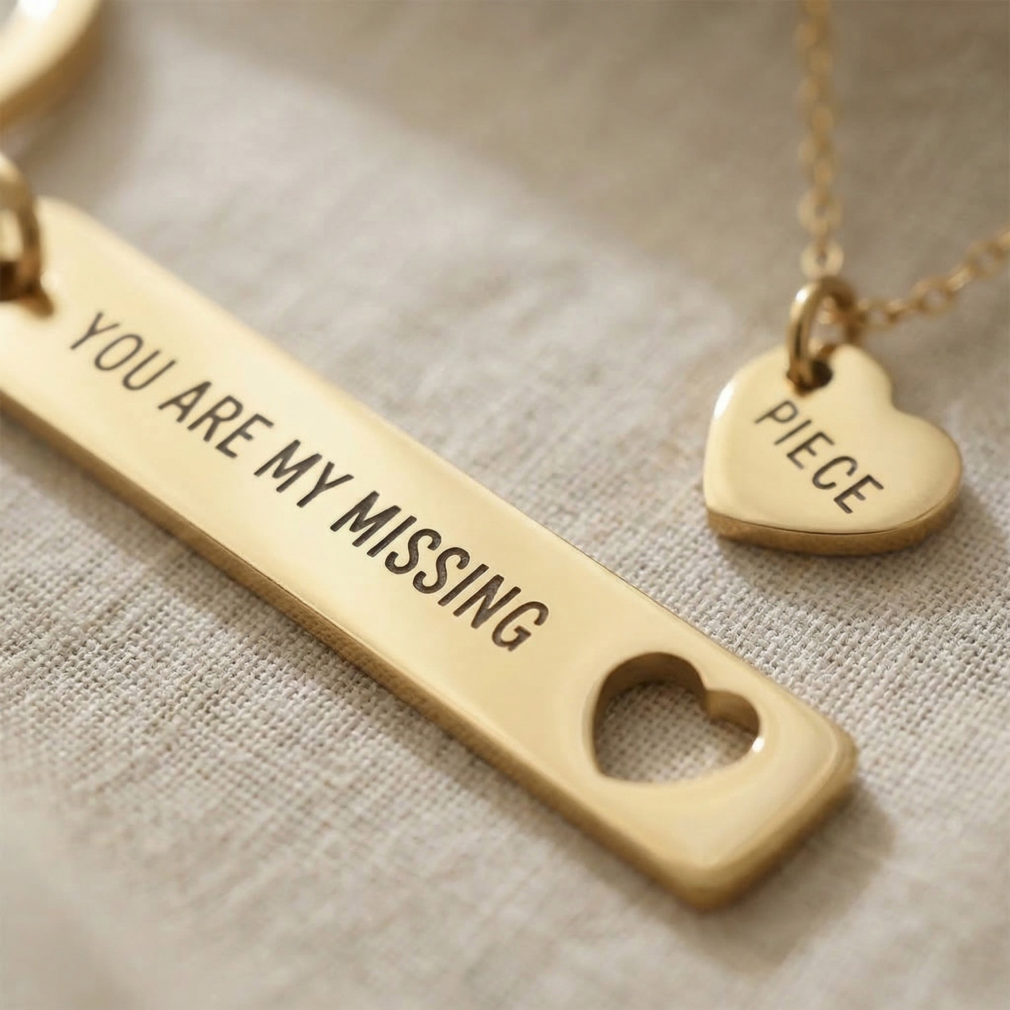 Close-up of missing piece necklace and keyring set with engraved message and heart charm detail