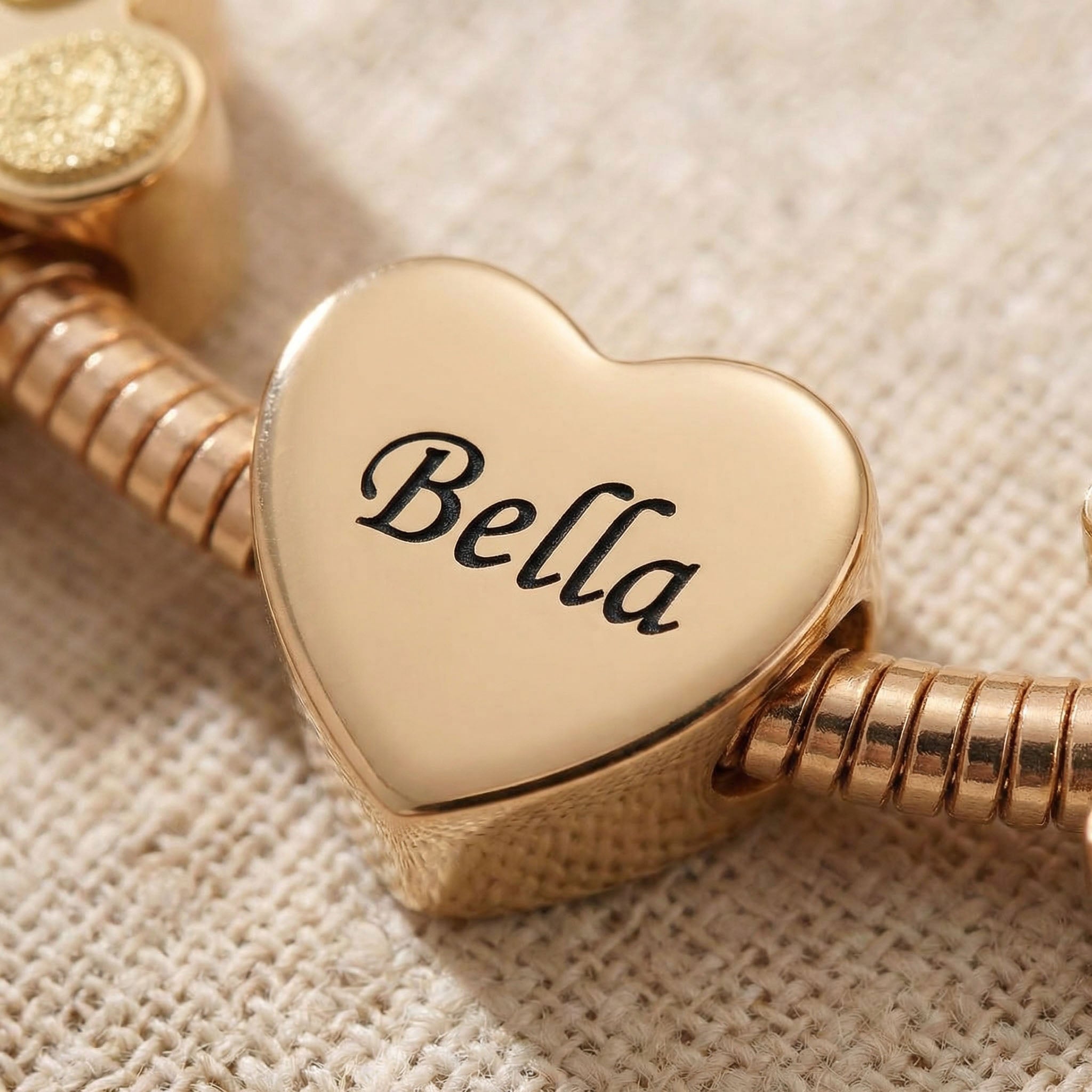 Close-up of moments charm showing detail of engraving and heart charm shape