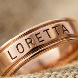 Close-up of personalised band ring with engraved name detail showing fine craftsmanship and finish