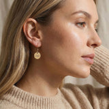 Woman wearing personalised earrings with engraved name disc design