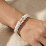 Women wearing personalised white leather bracelet with silver engraved name charms, modern custom jewellery option