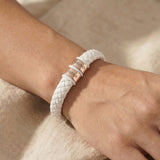 Women wearing personalised white leather bracelet with silver engraved name charms, modern custom jewellery option