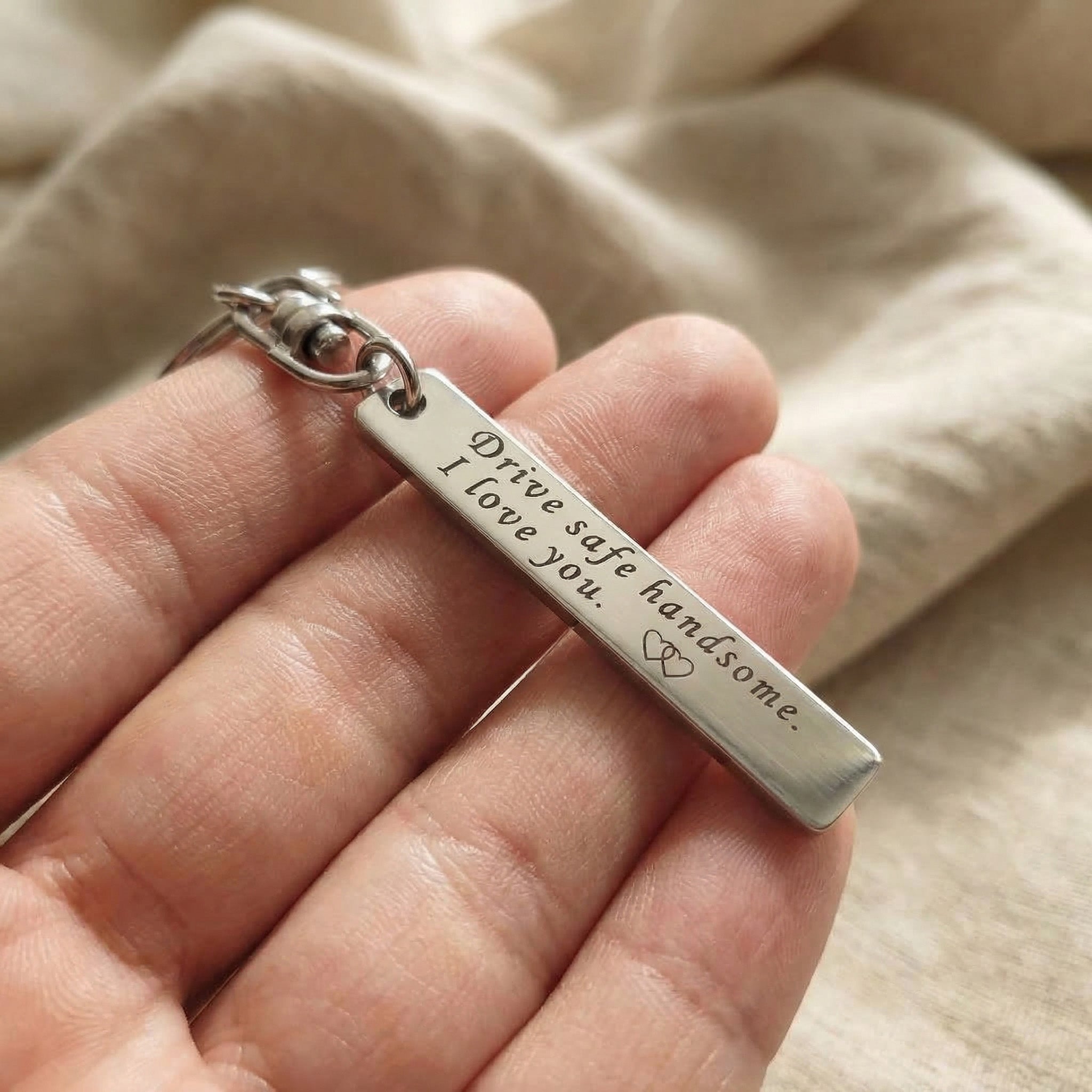 Hand holding personalised tag keyring with engraved message, everyday use keepsake