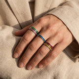Woman wearing river ring with colourful gemstone bands, elegant stackable jewellery for everyday wear
