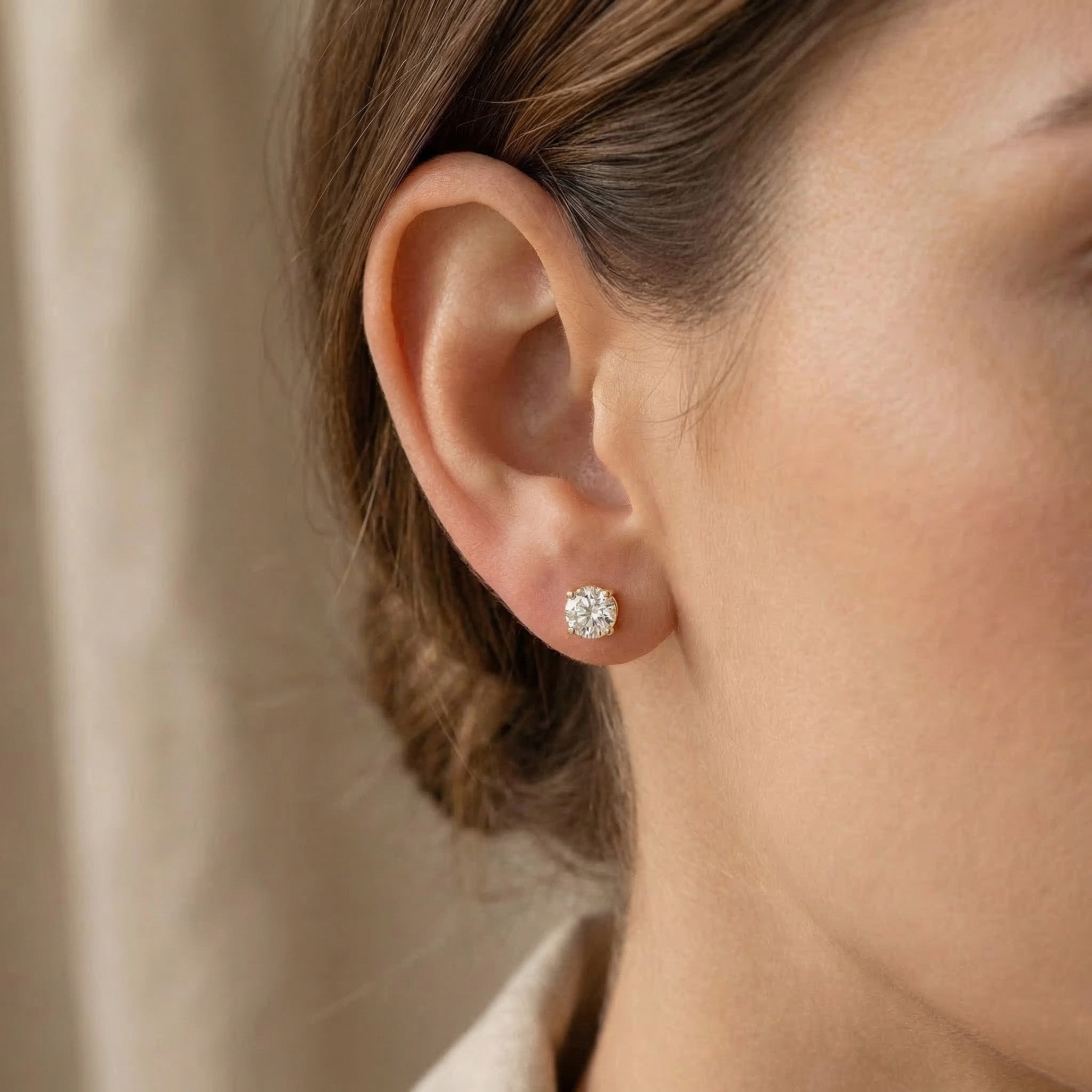 Woman wearing round stud earrings with sparkling stone, minimal everyday style
