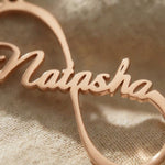 Close-up of single infinity name necklace with personalised name in flowing script design