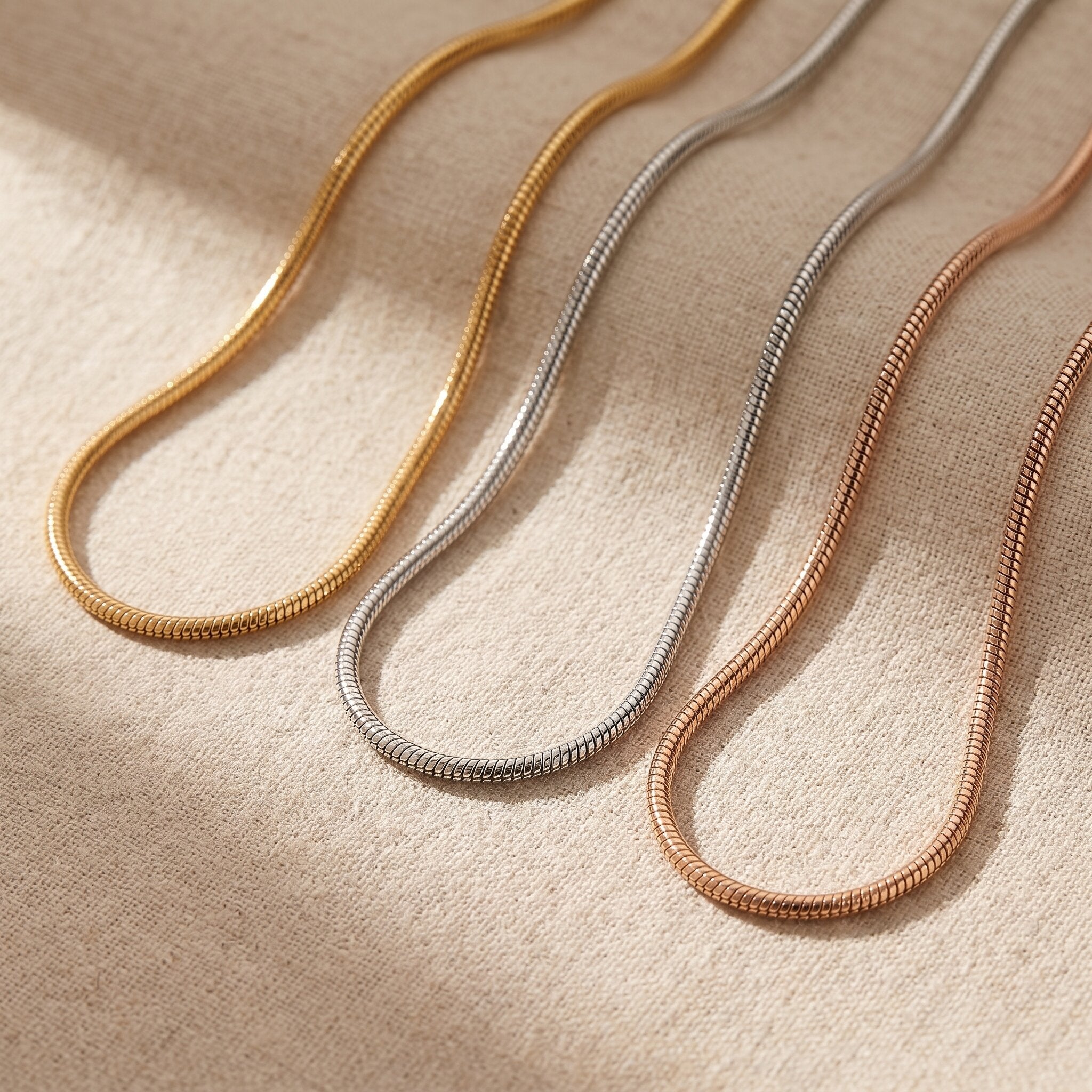 Snake chain necklace tone comparison showing gold, silver and rose gold minimalist chain finishes