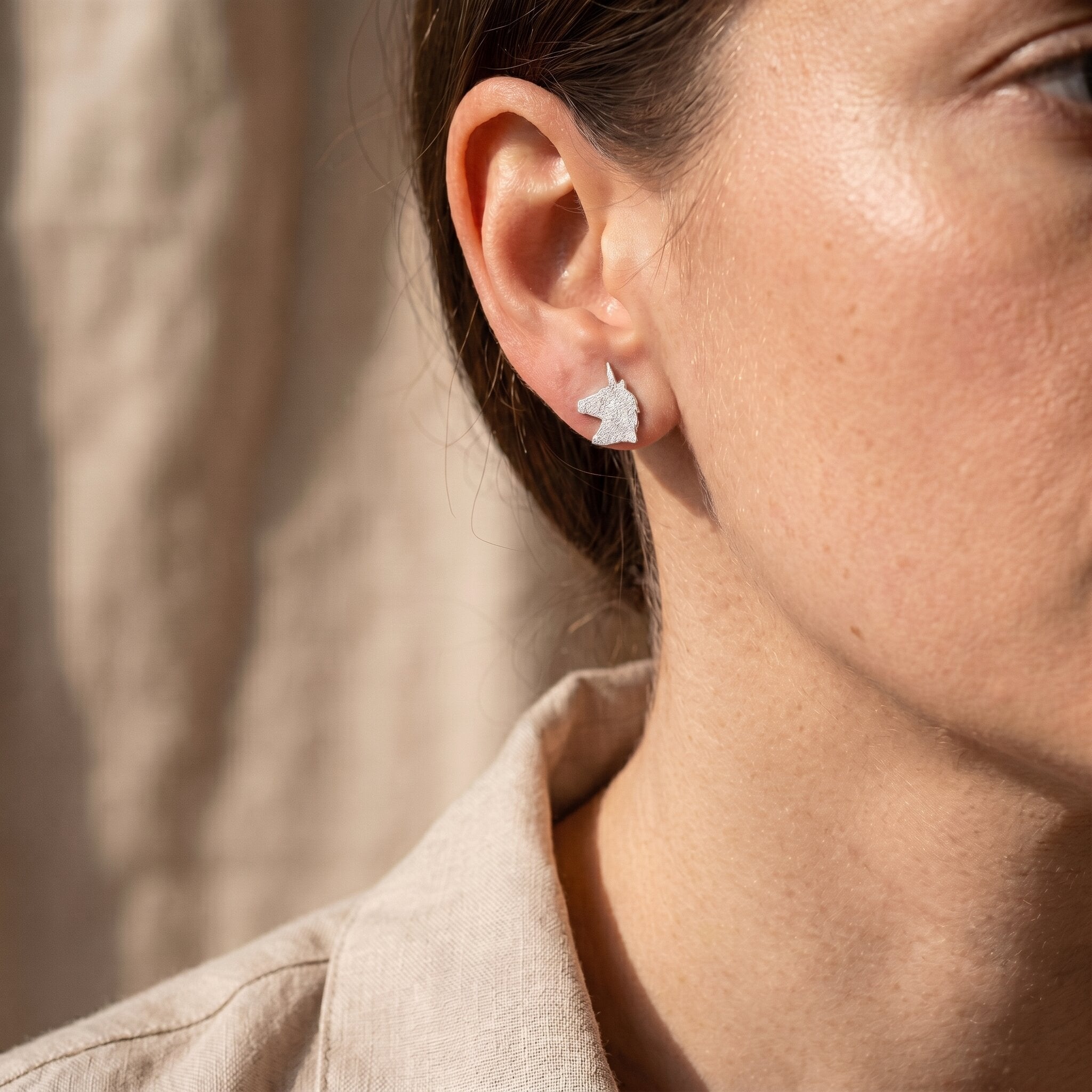 Woman wearing sparkling unicorn earrings, playful jewellery design perfect as gift for girls