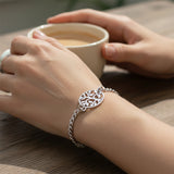 Belle Fever tree bracelet worn on wrist, silver chain charm jewelry. 
