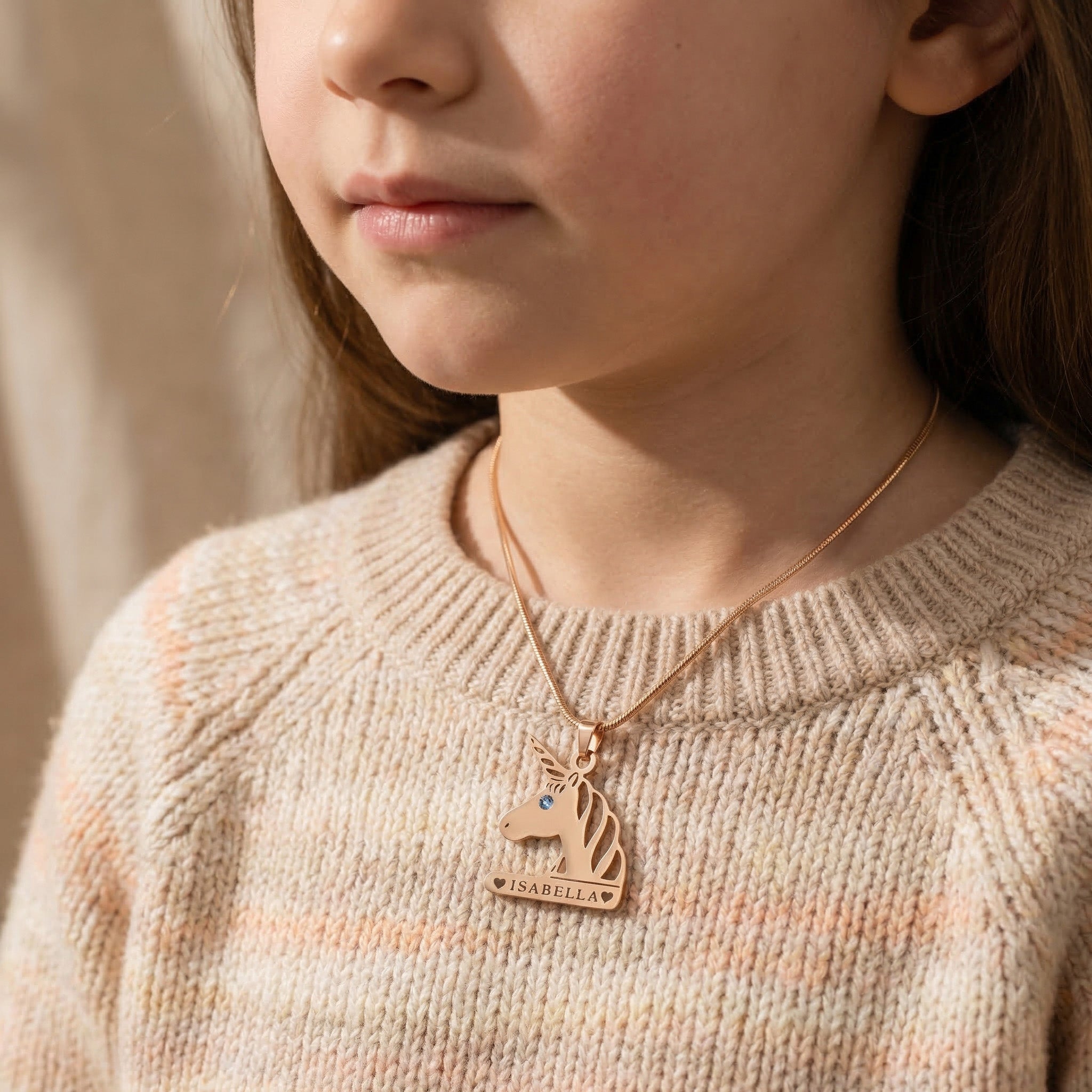 Girl wearing unicorn head name necklace with personalised name, playful everyday style